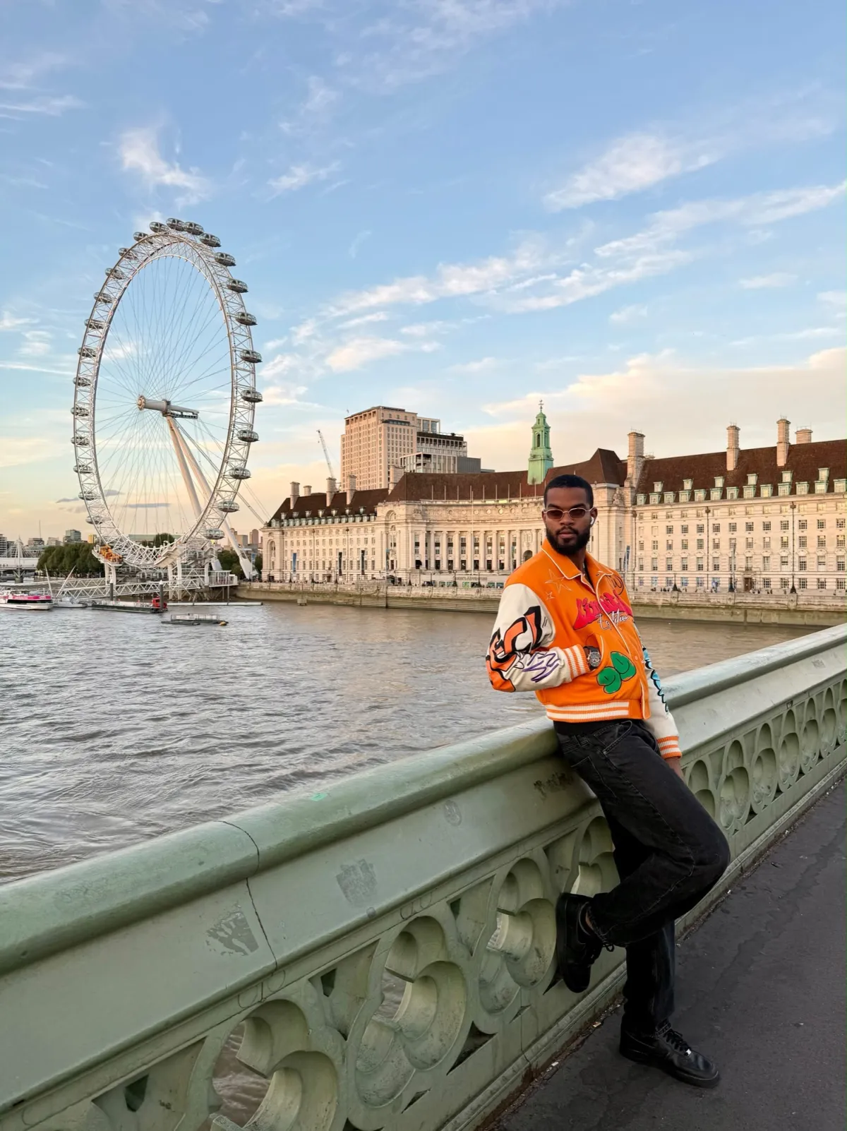 Derrick Théophile-Darmyn en veste orange devant le London Eye