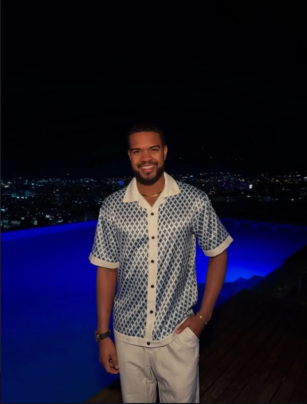 Derrick sur un rooftop de nuit devant une piscine bleue
