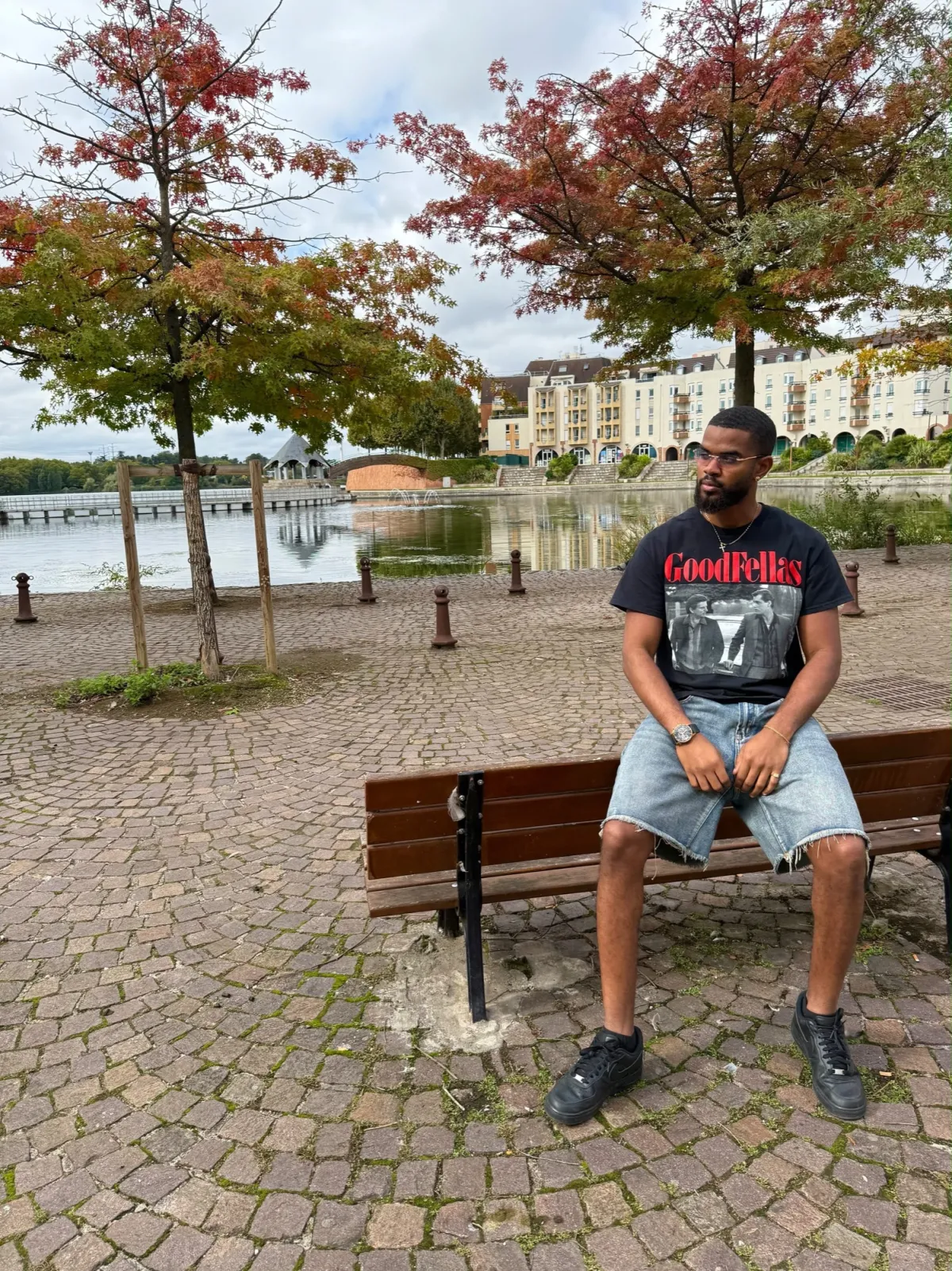 Derrick assis sur un banc au bord d'un lac